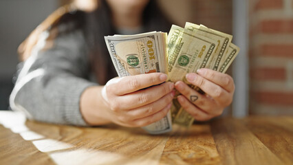 Hands of woman counting dollars at room