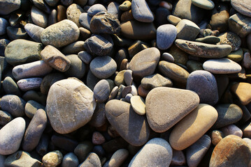 Stones on the seashore, pebbles on the beach, background. The sea coast.