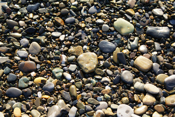 Stones on the seashore, pebbles on the beach, background. The sea coast.