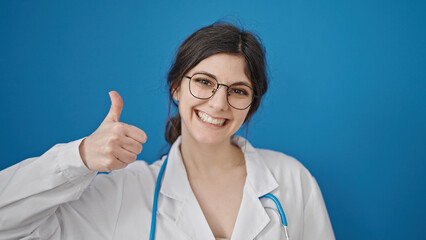 Young beautiful hispanic woman doctor doing thumb up over isolated blue background