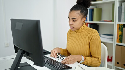 Young african american woman student using computer studying at the library