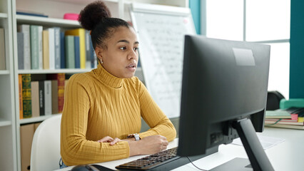 Young african american woman student using computer studying at the library