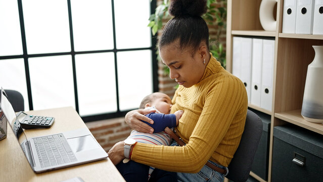 Mother and son business worker working while breastfeeding baby at office