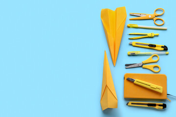 Composition with stationery supplies and paper planes on blue background