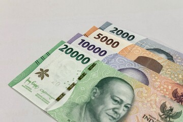 Close up of stacked Indonesian banknotes with isolated background.