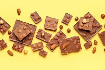 Sweet tasty chocolate with nuts on  yellow background