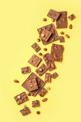 Sweet tasty chocolate with nuts on  yellow background
