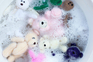 Soak toy teddy bears in laundry detergent water dissolution before washing.  Laundry concept, Top...