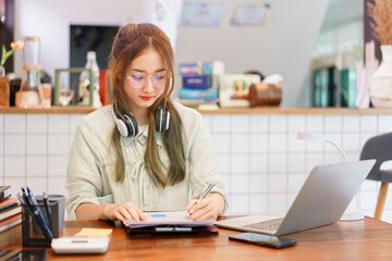 Coworking space office concept, Woman entrepreneur writing data and reading business document