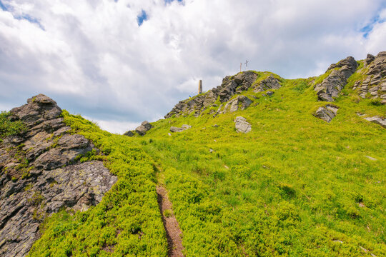 rocky formations on the steep grassy slopes of pikui mountain. nature scenery of ukrainian carpathians on a sunny summer day. blue sky with fluffy clouds