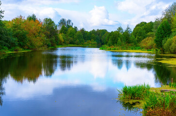 Obraz premium Forest landscape with lake, clouds, colored foliage