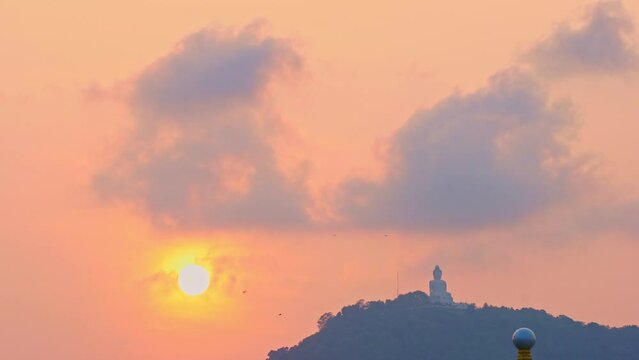 Phuket big Buddha in beautiful sunset..the sun shines through the clouds..The beauty of the statue fits perfectly with the charming nature..Gradient color. sea texture, .cloud scape background.
