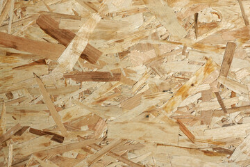 Oriented Strand Board. Chipboard building material. OSB wooden panel made of pressed sandy brown wood shavings as background front view