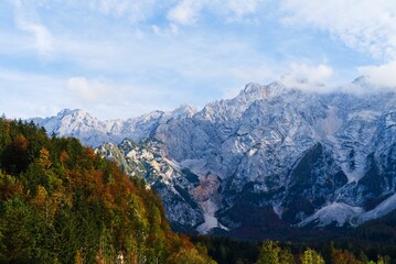 Landscape view of the Alps mountain range with autumn trees on the rocks