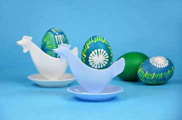 Beautiful hand painted unique easter eggs in plastic hen egg cup holder stock images. Easter decoration with colored eggs on a blue background stock photo. Retro chicken egg cup still life