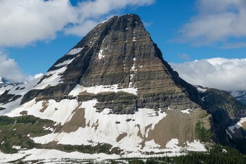 Scenic shot of a rocky hill with glacier and snow on its slopes under the blue sky