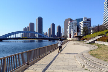 Fototapeta na wymiar Promenade on the right bank of the Sumida River, Eitai bridge and Chuo-Ohashi bridge in far background, Nihonbashi-Hakozaki-cho, Chuo-ku, Chūō, Tokyo, Japan