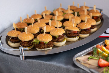 Viele kleine Hamburger vom Partyservice auf einem Tablet
