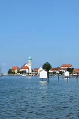 Obraz premium Bodensee, Wasserburg am Bodensee, Boote, Segelboote, Badehäuschen, Anlegesteg, Hafen und Kirche St. Jakob im Morgenlicht an einem schönen Sommermorgen
