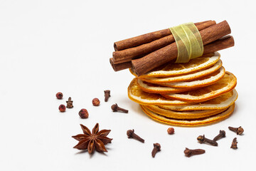 Stack of orange chips and cinnamon sticks. Spices on the table.