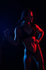 Young woman in underwear is in the studio with neon lights.