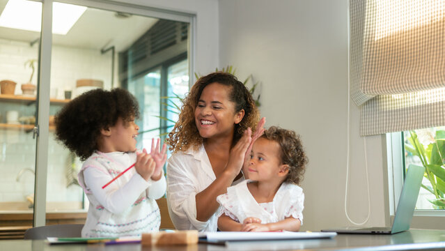 African American mother playing with her daughters in home