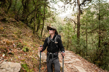 Fototapeta na wymiar A young traveller trekking on forest trail , Nepal