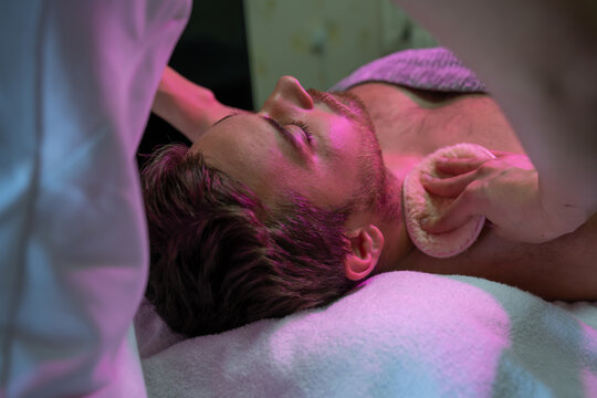 Jeune homme en soin esthétique avec des éponges