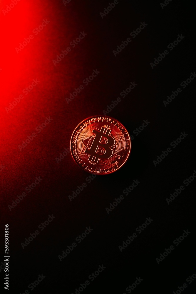 Poster vertical shot of a bitcoin isolated on a red-to-black gradient background