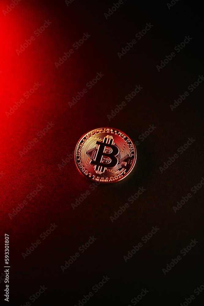 Poster vertical shot of a bitcoin isolated on a red-to-black gradient background