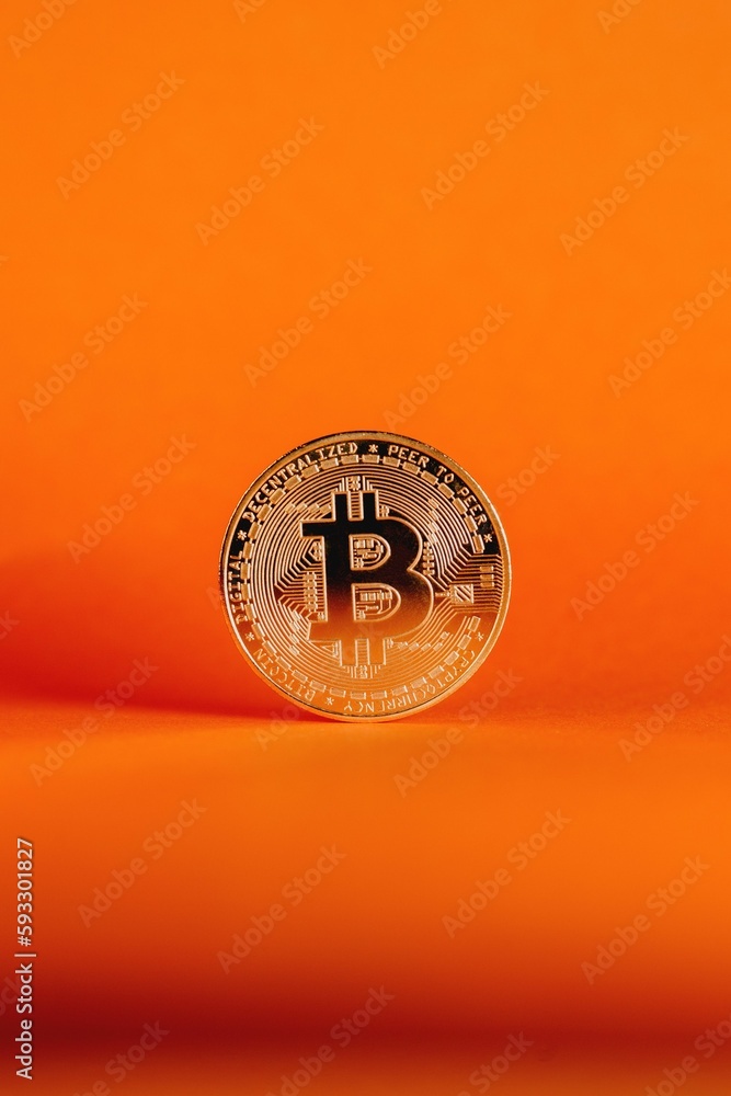 Poster vertical shot of a bitcoin isolated on an orange gradient background