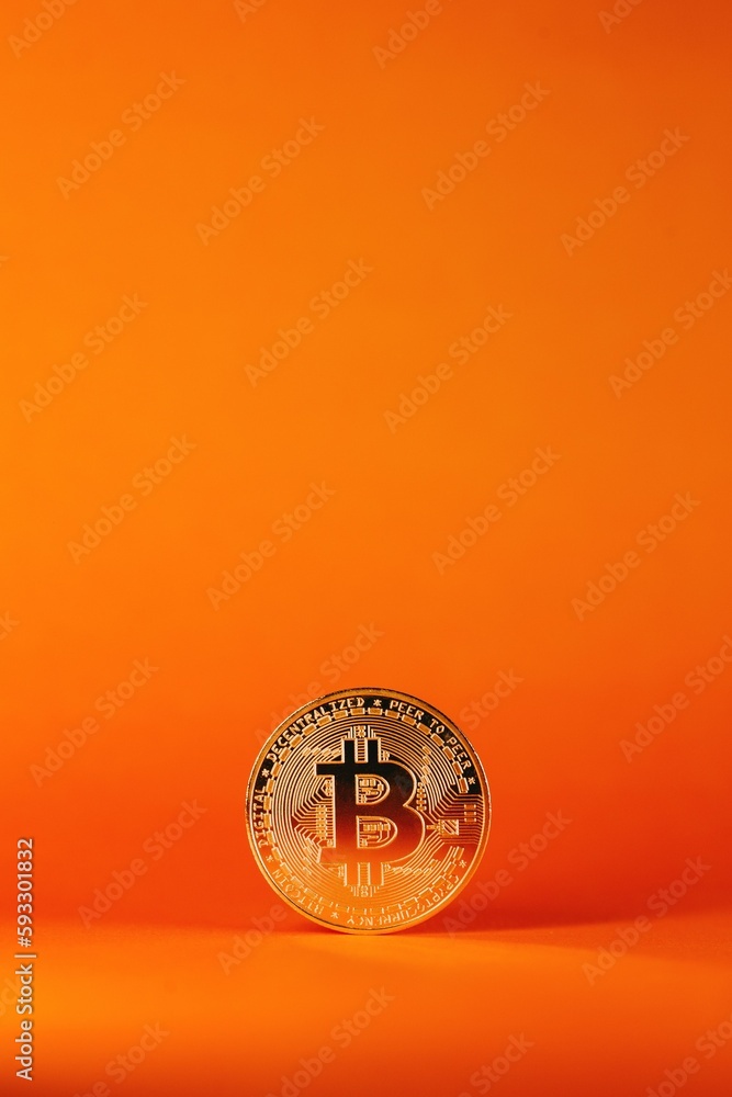 Poster vertical shot of a bitcoin isolated on an orange gradient background
