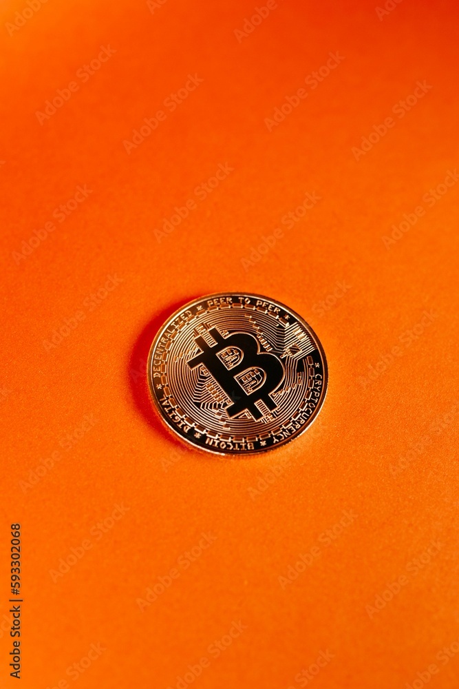 Poster vertical shot of a bitcoin isolated on an orange gradient background