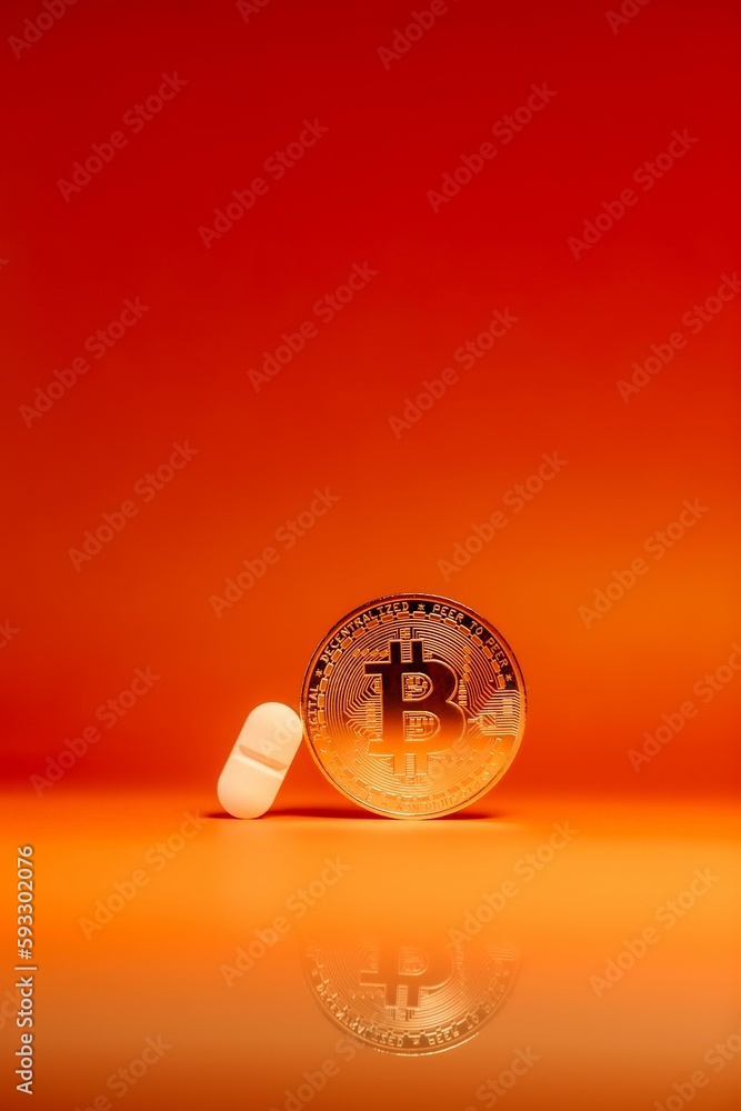 Poster vertical shot of a bitcoin and a pill isolated on an orange gradient background