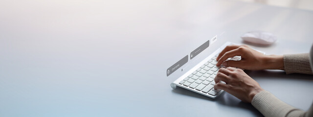 An individual is typing on a laptop keyboard showing a hologram interface to a member login, a...