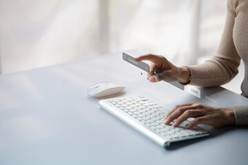 An individual is typing on a laptop keyboard showing a hologram interface to a member login, a businessman is going to access the company's membership system, check the information of the parties.