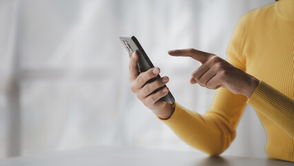 A person holds a mobile phone to use social media on a smartphone, communicating via the Internet on a smartphone. The concept of using technology in communication.