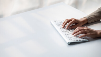 Person typing on a computer keyboard, businessman is working in a startup company's office, he is typing messages to his colleagues and making financial documents summarizing the meetings. Copy space.