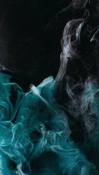 Smoke veil. Paint water. Night haze. Teal blue color glitter dust particles mist floating on dark black abstract art background with copy space.