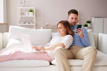 Family Couple Using Laptop And Phone