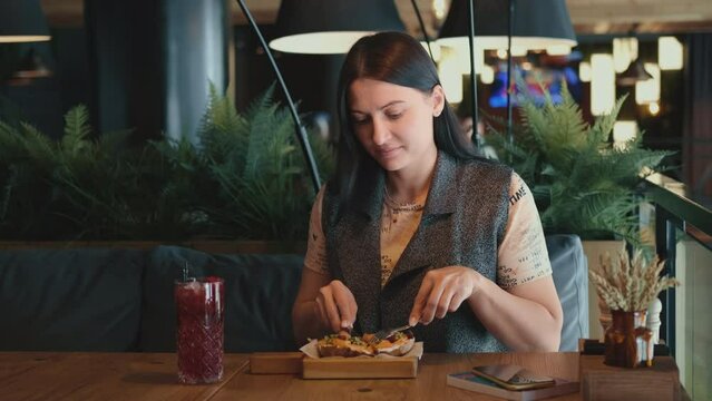 A female restaurant critic tries food in a restaurant.