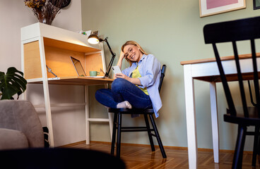 Smiling woman working remotely from home on her laptop.