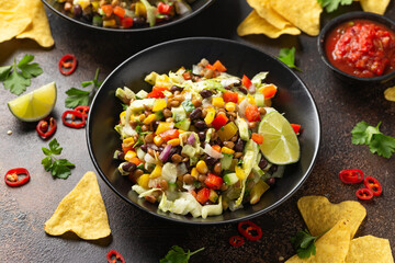 Mexican style salad of black beans, lentils, corn, tomato and lettuce with a salsa and tortilla chips