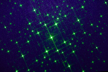 On a dark blue background in fine grain, a pattern of green stars and green dots