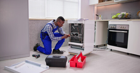 African Repairman Repairing Dishwasher Appliance
