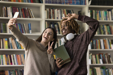 Multiethnic students, girl, guy, stand, looks at mobile phone screen, smile pose for selfie photo,...