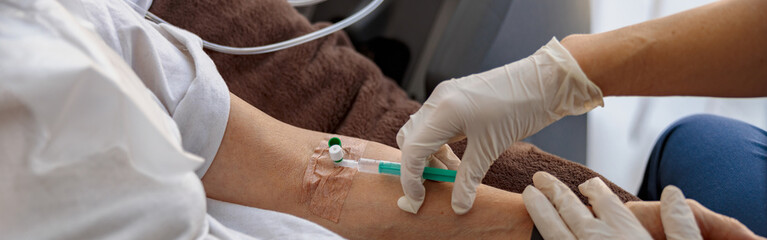 Nurse putting a drip in the arm of her patient in modern medical clinic. High quality photo