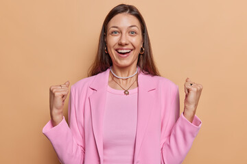 Euphoric positive businesswoman glad to win case clenches fists feels like winner feels very happy...