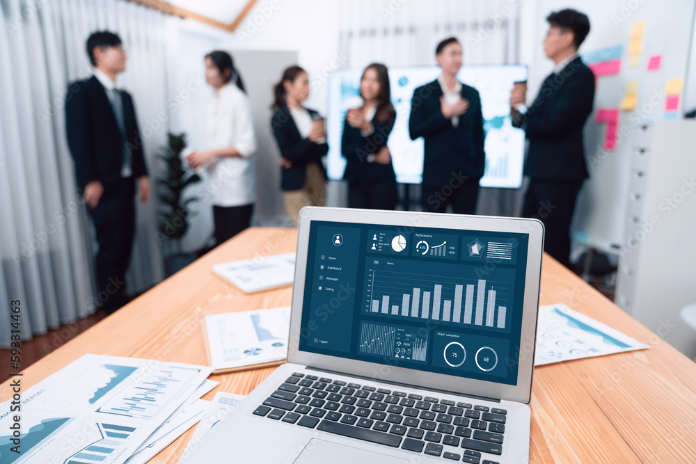 Poster Focus laptop monitor display dashboard report by business intelligence, analyzed financial data for planning market strategy with blur background of standing office worker discussing in harmony office