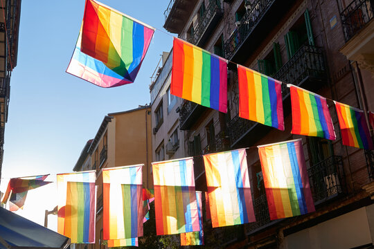 lgbt flags hanging over the street of the city center at sunset. Chueca, the epicenter of gay pride in Madrid